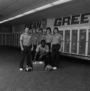 Football staff posing with equipment