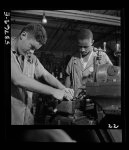 National Youth Adminstration work center (NYA), Brooklyn, New York. Two men, white and Negro, who are receiving training in machine shop practice, shown setting up shaper work to cut forty-five degree angles at base for surface gauge