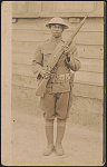 [Unidentified African American soldier in uniform and helmet with rifle and knife hanging from cartridge belt]