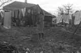 Mrs. Rosa Lee Turner hanging laundry on a clothesline in the dirt yard behind her house in Montgomery, Alabama.