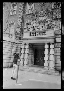 Sympathizer points to Black students on small balcony over entrance to Administration Building at Boston University