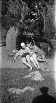Three young women in swim suits and caps lying on rock