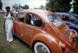 Woman leaning on Volkswagen automobile