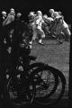 Young man on a bicycle, watching football players from Baldwin Junior High School in Montgomery, Alabama, practice in a yard on Clayton Street.