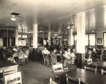 African American students, probably of college age, seated at tables in a library.