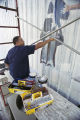 Lorenzo Green painting a patriotic mural on the side of Lambert's Cafe on Highway 59 in Foley, Alabama.