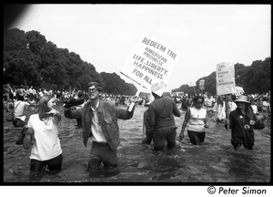 Splashing in the Reflecting Pond during the Poor Peoples’ Campaign Solidarity Day Protesters holding signs reading 'Redeem the American promise, life, liberty, happiness for all Jun 19 Solidarity Day" and 'Jobs or income for all Americans'