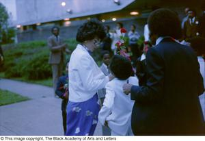 Photograph of woman receiving rose from young child