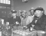 Five men, three African-American, socializing over beers at a local bar, ca. 1950's