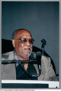 Jazz pianist smiling while looking down at microphone