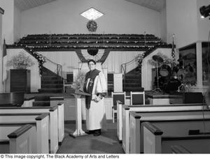 Photograph of Dr. S. M. Wright standing in a church's nave #3