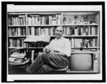 [Ralph Ellison, full-length portrait, seated in his apartment]