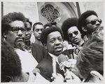 [Lucius Walker speaking into microphone with James Forman at his side, probably outside Riverside Baptist Church, New York, New York]