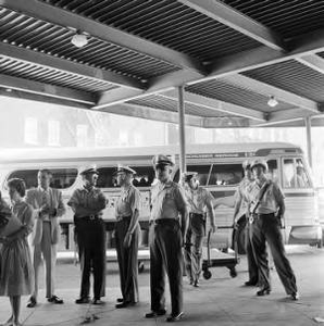 Police officers standing outside a bus to prevent Freedom Riders from boarding at the Greyhound station in Birmingham, Alabama.