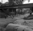 Children playing under railroad trestle.