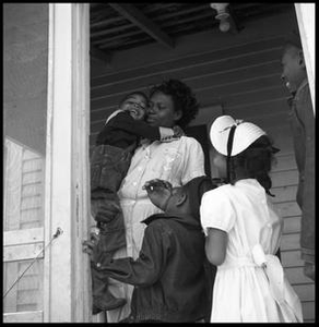 Woman Standing in a Porch Doorway with Children