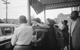 Juanita Jones hugging her sister, Maxine McNair, in front of Social Cleaners across from 16th Street Baptist Church, after the church was bombed.