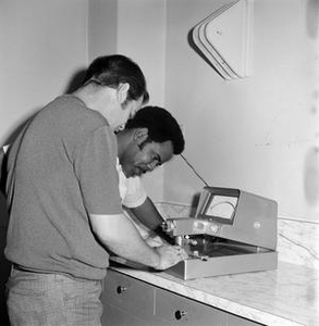 Two men working with a machine