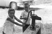 Children getting water from a hand pump during a cookout in the Madison Park community in Montgomery, Alabama.