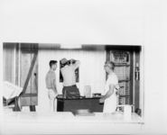 Mississippi State Sovereignty Commission photograph of three males standing inside the ticket office of the Trailways bus depot, Winona, Mississippi, 1961 November 1