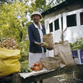 Hattie Dillard setting out vegetables at her produce stand, probably in Birmingham, Alabama.