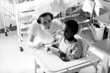 A Marquette nursing student comforts a crying child, 1968-1969