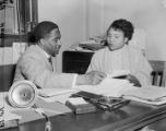 Arthur Shores and Autherine Lucy in his office in Birmingham, Alabama, probably after her exclusion from classes at the University of Alabama.