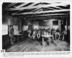 Class of illiterates, Army YMCA Building #1, Camp Travis, Texas. These men are from first group, 165th Depot Brigated. Building is devoted exclusively to Negro troops. Negro secretary is teaching class. Lesson absorbing attention of classics, "See t...