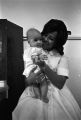 Emma Pearl Watkins holding a baby inside a beauty salon in Montgomery, Alabama.