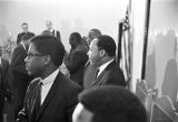 Martin Luther King, Jr., and others, standing and talking to one another during a meeting at Maggie Street Baptist Church in Montgomery, Alabama.