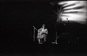 Taj Mahal in concert at Northfield, Mass.: Taj Mahal seated, playing guitar