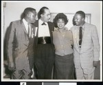 Three African American men wearing badges reading "Official" and "Chairman" posing with woman, Los Angeles, ca. 1951/1960