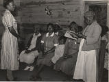 Juanita Coleman, teacher and National Youth Administration leader, listening to one of her pupils in the adult class reading.