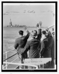 Part of a group of 171 aliens illegally in the country wave goodby to the Statue of Liberty from the Coast Guard cutter that took them from Ellis Island to the Home Lines ship Argentina in Hoboken for deportation