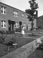 Woman Watering Plants Outside of Sumner Field Homes