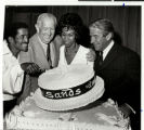 Photograph of Sammy Davis, Jr. with others cutting a cake