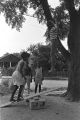 Diane Foster and Elizabeth Ellis playing on a make-shift seesaw in the dirt yard in front of a brick house in Newtown, a neighborhood in Montgomery, Alabama.