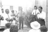 Thumbnail for Stokely Carmichael speaking to a group of people standing outside a brick church building in Prattville, Alabama, during a meeting of the Autauga County Improvement Association.