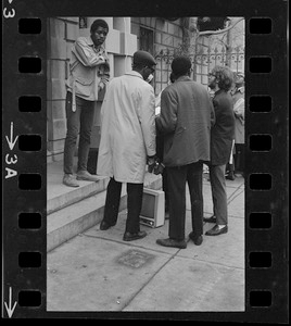 People outside Boston University administration building with a television