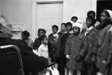 Children in the group "Buds of Promise" from Mt. Zion AME Zion Church in Montgomery, Alabama, singing to an elderly woman in her home.