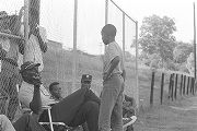 Man speaking to a young boy during a boys' baseball game, probably in Montgomery, Alabama.