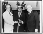 [Hattie McDaniel standing between, and shaking hands with, Walter F. White and another man]