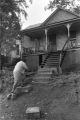 Woman climbing steps of slum house.