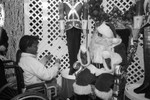 Baldwin Hills Crenshaw Plaza visitor posing with Santa, Los Angeles, 1989