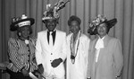 Three women and a man pose wearing homemade hats, Los Angeles, 1989