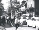 Firefighters, police, photographers, and citizens gather on street after riot, Rochester, NY, 1964