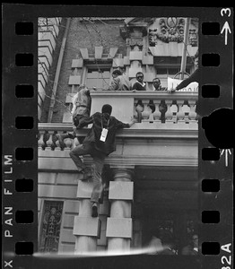 Student climbs up Boston University administration building during sit-in