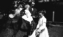 Unidentified man with children on a horse and dog