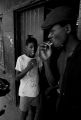 Edward Taylor and James "Bubba" Bradley eating ice cream sandwiches on the front porch of Pugh's Superette on Foster Street in Newtown, a neighborhood in Montgomery, Alabama.