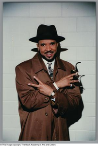 Medium shot of a man smiling and posing for the camera, with his arms crossed